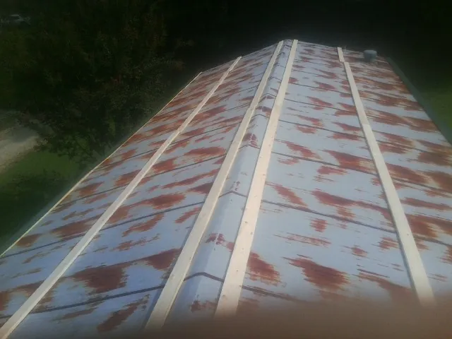 Rusted metal roof panels with new wood purlins before replacement — Storm Damage Roof Repair in Camby by Roofing Brothers