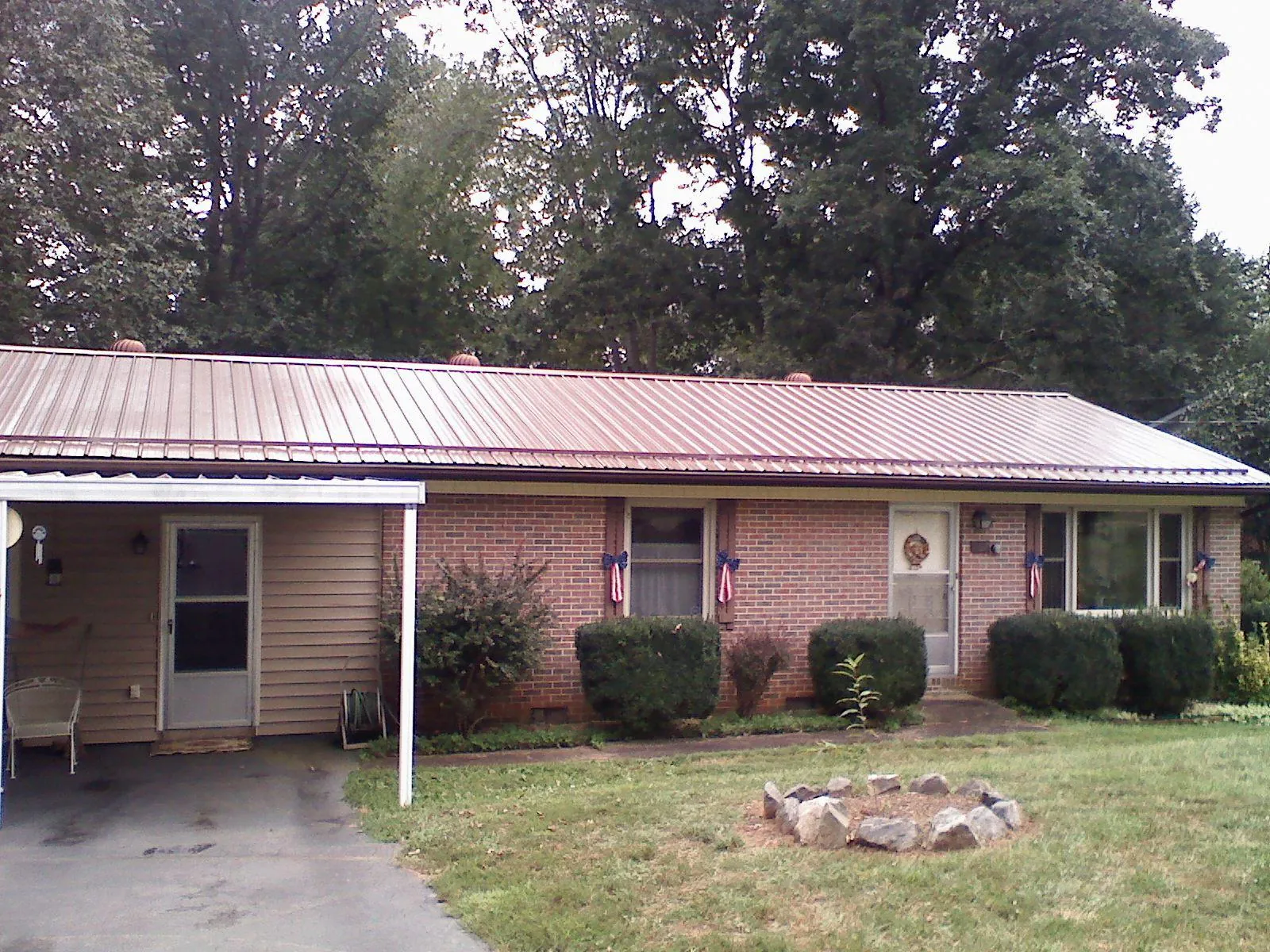 Bronze metal roof and carport on a brick ranch home — Roof Repair work by our crew in Camby